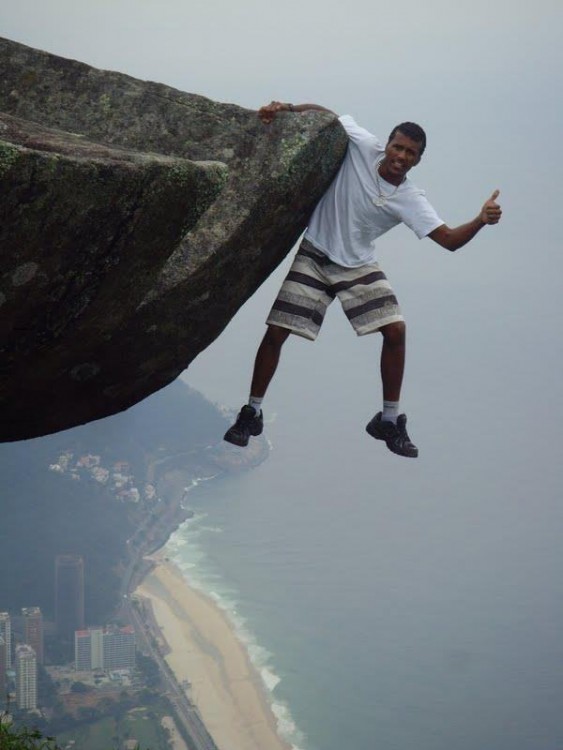 hombre tomado de una mano desde una cima alta para tomarse una fotografía