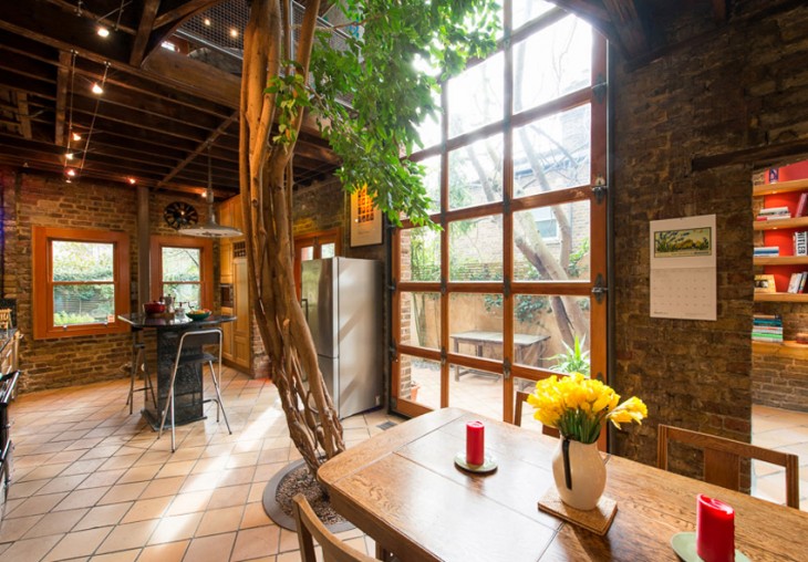 casa con un arbol dentro y un jardin muy romantico