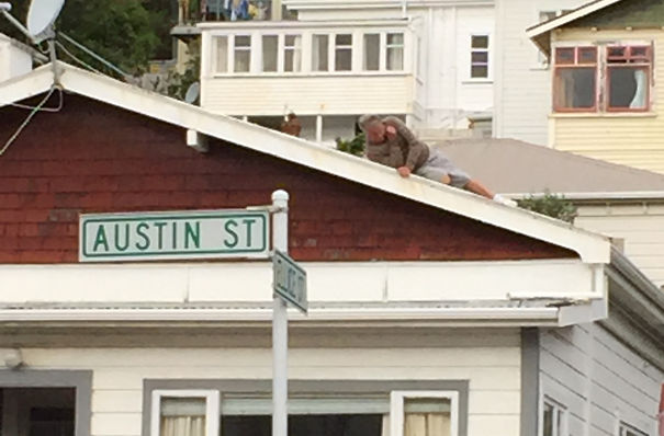 hombre se va resbalando por el techo de su casa