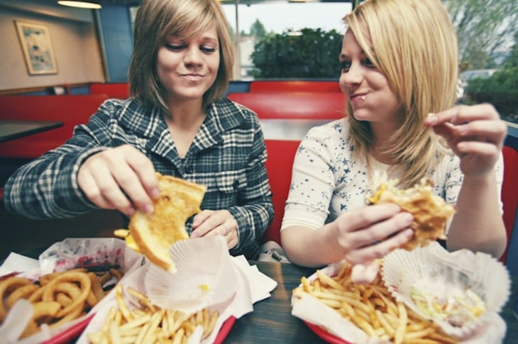 mujeres comiendo comida rapida y grasosa