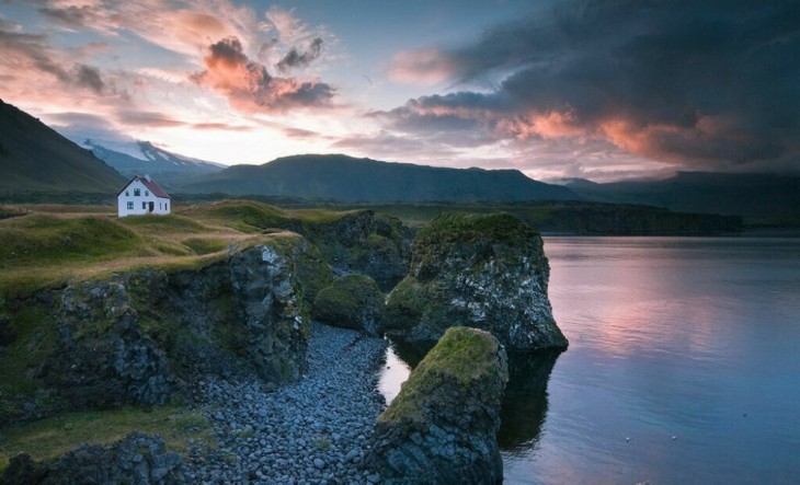 Casa solitaria cerca de un lago en medio de un área verde 