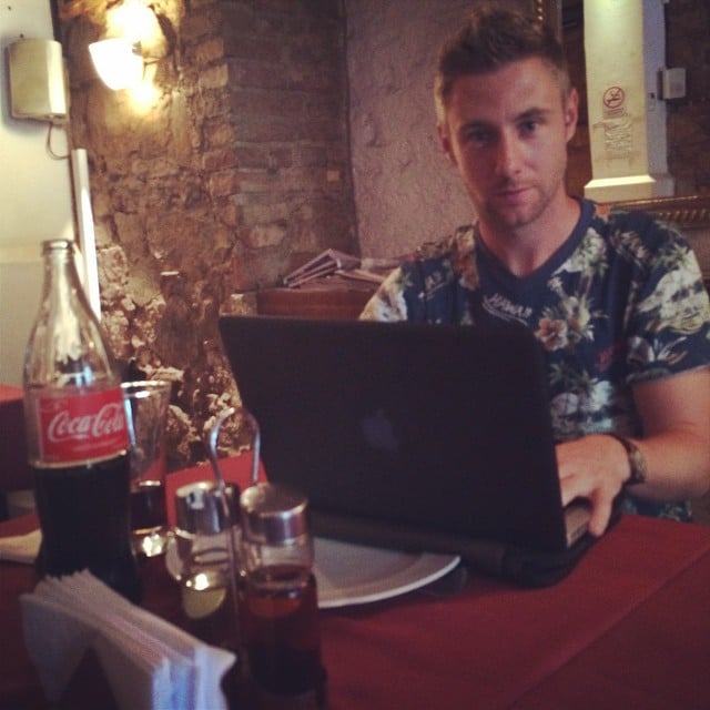 Johnny Ward sentado detrás de su laptop en un restaurante 