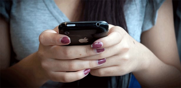 Manos de una mujer mandando mensajes desde su celular 