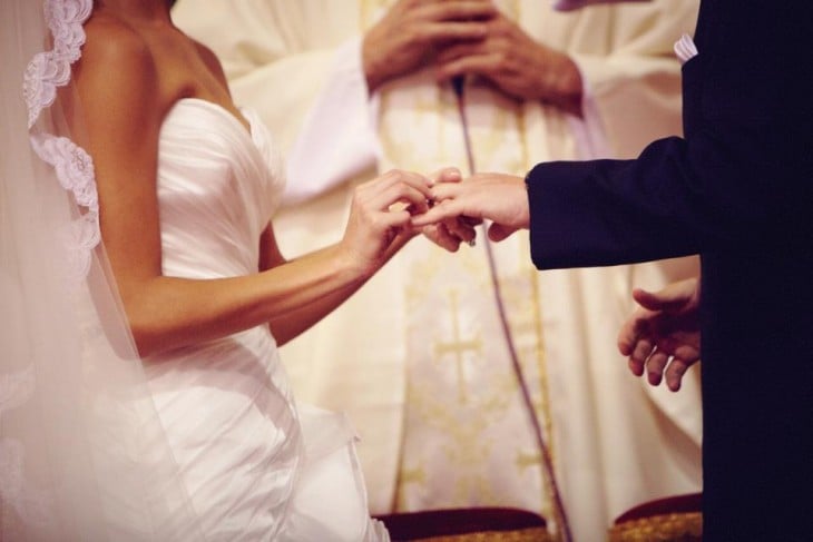 Hombre y mujer recibiendo los votos matrimoniales 