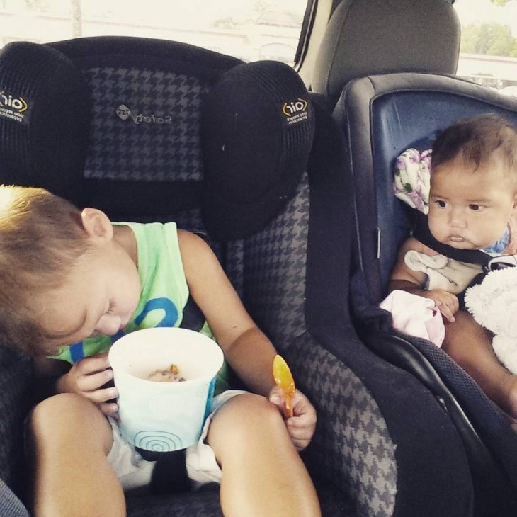 dos niños sentados en la parte trasera de un coche en donde un niño esta dormido