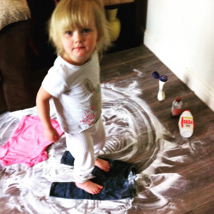 Niño arriba de un pantalón sobre un piso lleno de crema y polvo blanco 