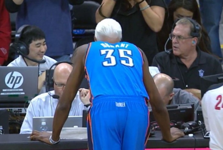 Basquetbolista recargado en la mesa de los comentaristas donde parece tener el cabello lleno de canas 