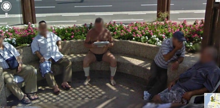 Extraña fotografía de un hombre leyendo el periódico en una calle solo en ropa interior 