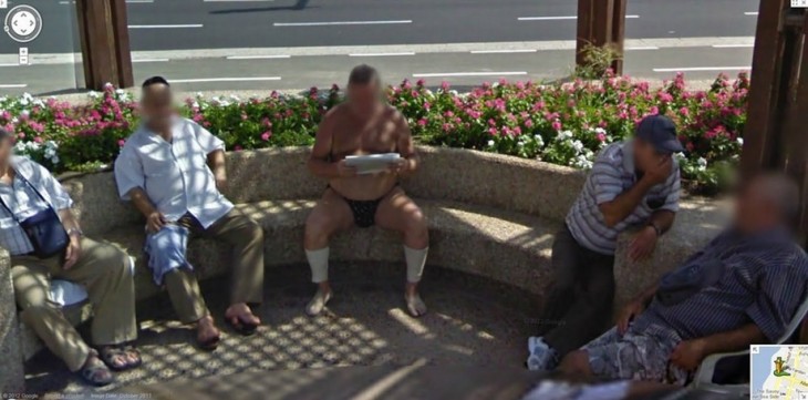 Extraña fotografía de un hombre leyendo el periódico en una calle solo en ropa interior 