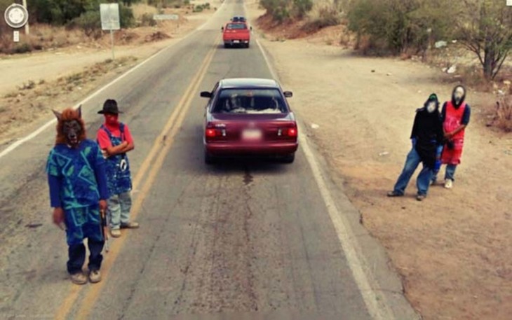 Personas con máscaras de películas de terror en una carretera 