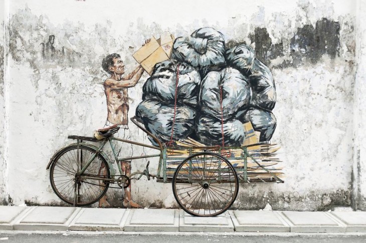 Anciano apilando basura en un triciclo 