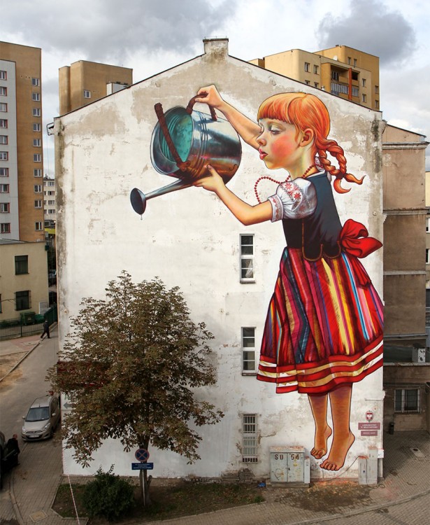 Grafiti de una niña en una pared simulando que riega un árbol 