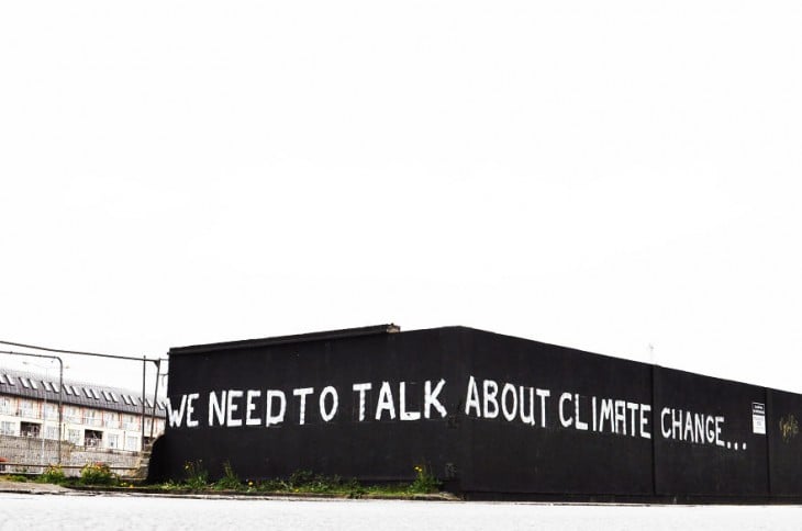 Frase "tenemos que hablar del cambio climático" pintada en una pared 