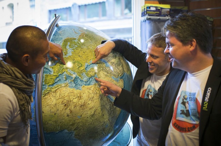 Gunnar y sus amigos señalando en un globo terráqueo 