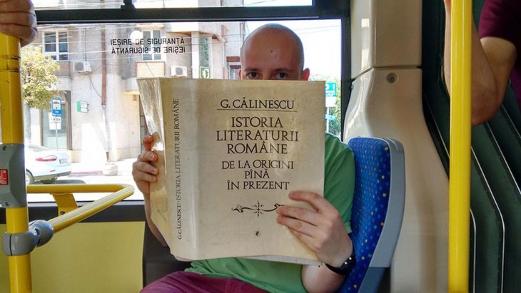 Un hombre con un libro en el autobús tapando la mitad de su cara 