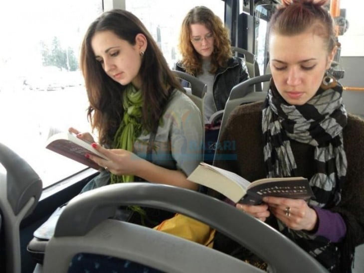 Chicas leyendo un libro en el transporte público en Rumania 