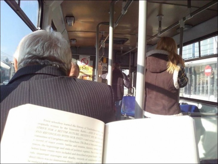 Espalda de una persona en el autobús y una persona con un libro en sus manos 