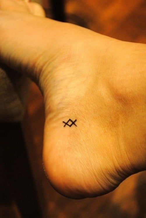 Tatuaje de Símbolo griego inguz en un pie 