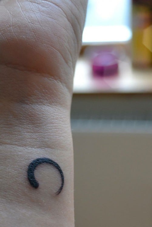 Tatuaje con el símbolo zen en una mano 