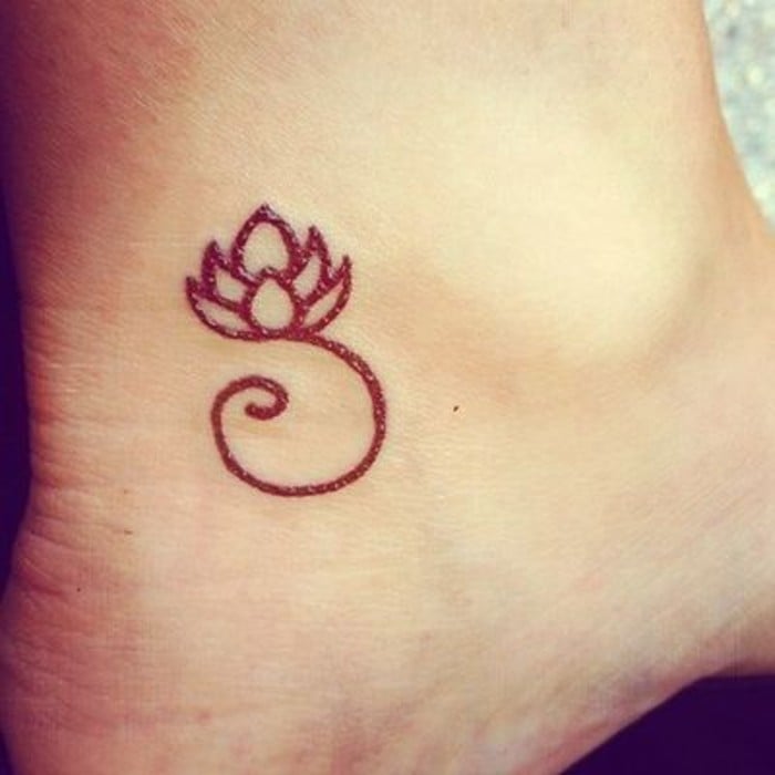 Tatuaje con una flor de loto en un tobillo 