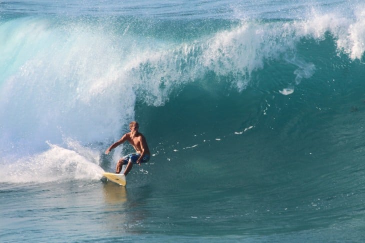 Chico practicando surf en la costa norte de República Dominicana