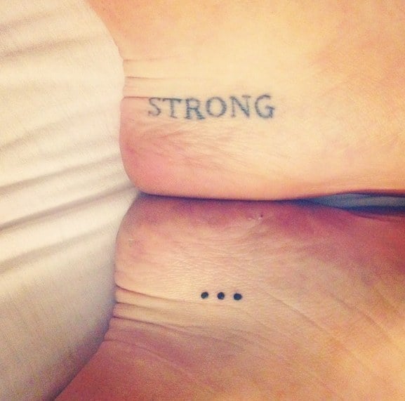 Tatuaje en un pie con la palabra "strong" 