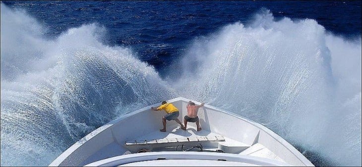 hombres luchando contra el oleaje del mar alto