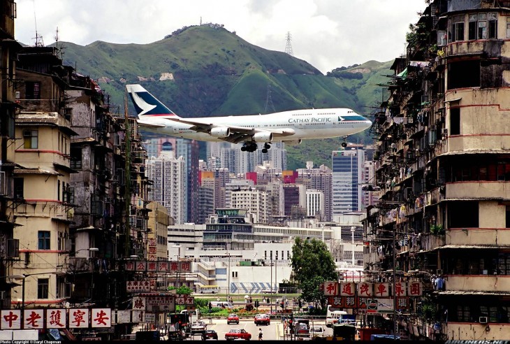 avion atravesando los edificios de hong kong