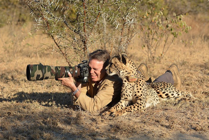Fotógrafo acostado en el suelo tomando una foto junto a un jaguar 