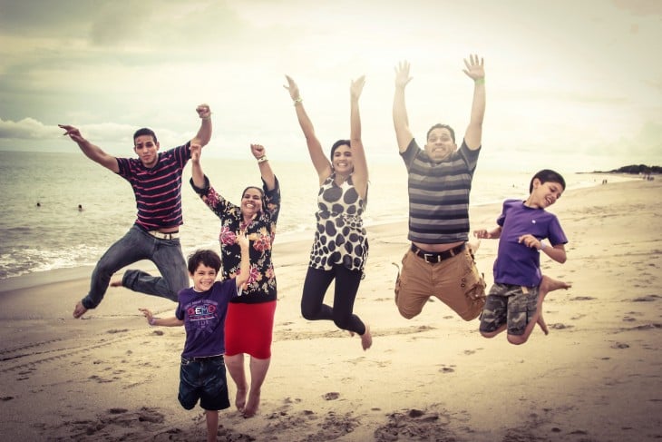 familia panameña saltando frente a la playa