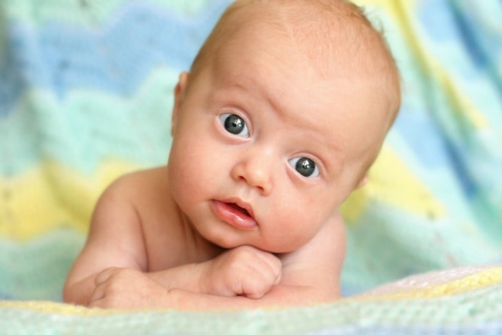 Bebé con cara de sorprendido mira hacia el frente de la cámara