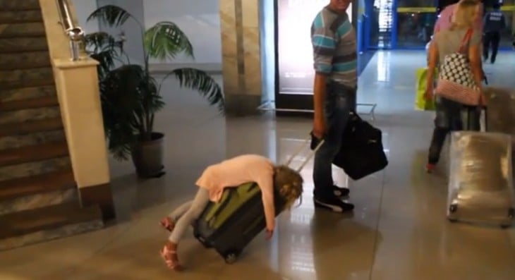 NIÑA DORMIDA SOBRE LA MALETA DE SU PAPA EN EL AEROPUERTO