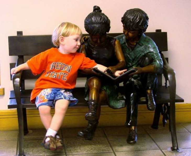 niño platicando con unas estatuas