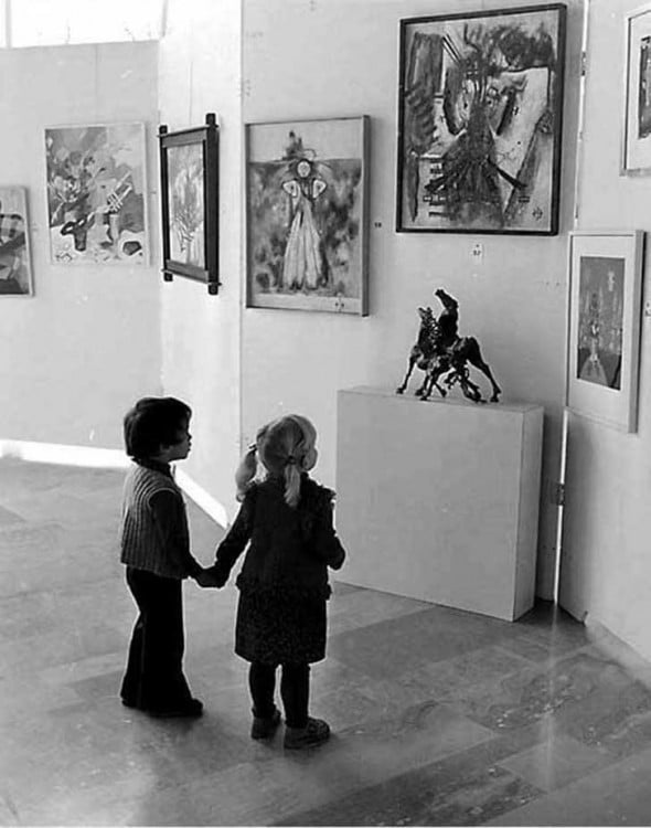 niños viendo una escultura de los caballos