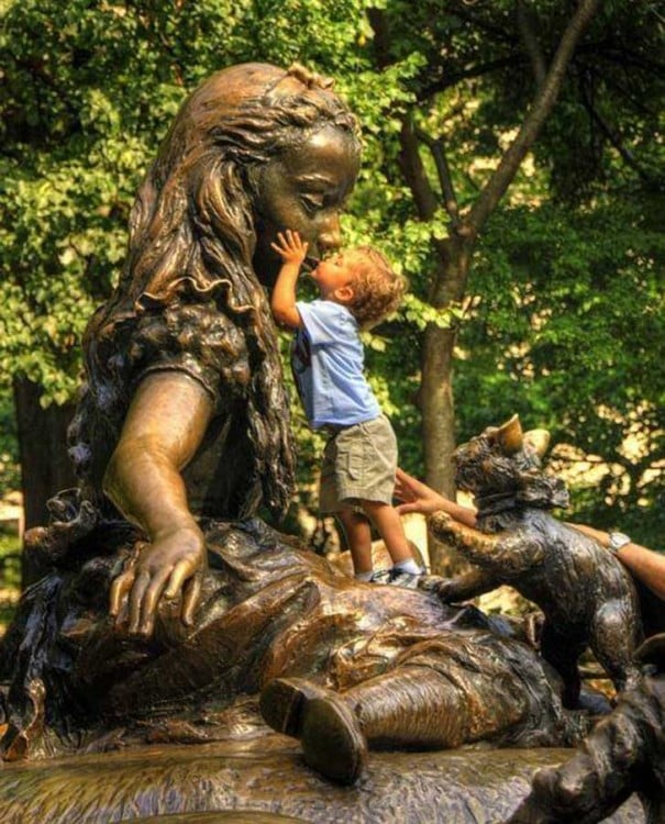 niño dandole un beso a la estatua