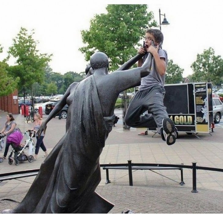 niño simulando que la estatua lo ahorca