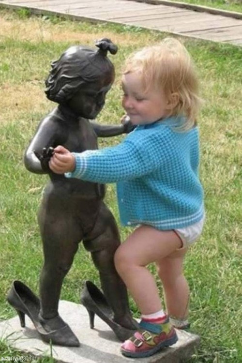 niña bailando con una estatua de niña con zapatillas