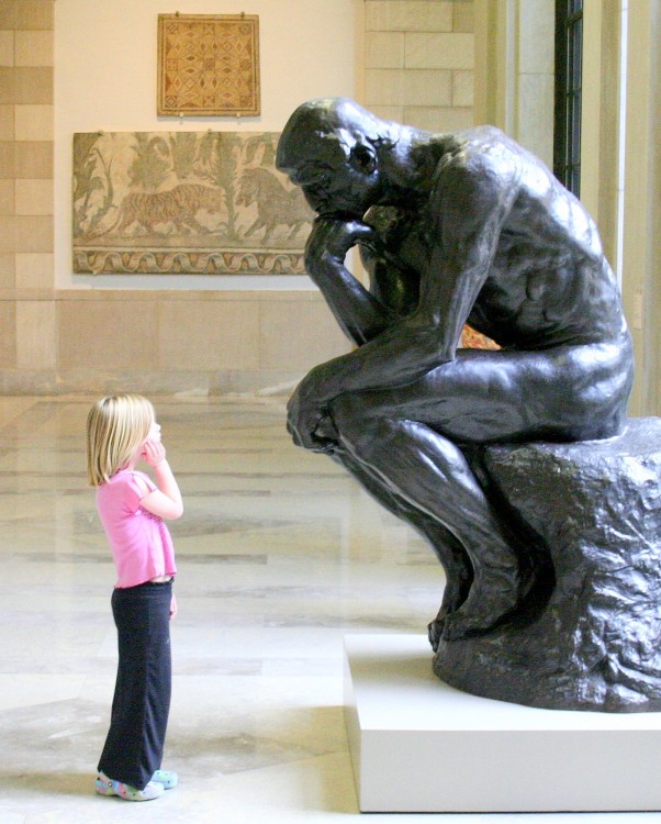 niña imitando la pose del pensador