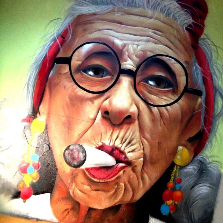 arte urbano en una de las paredes de España del rostro de una mujer fumando 