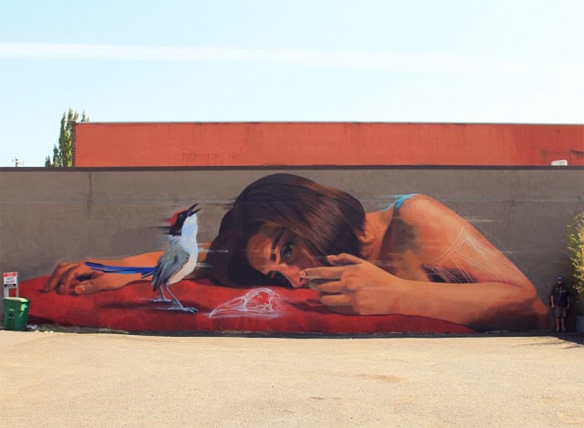 graffiti en una pared de una persona frente a un pájaro en las calles de Estados Unidos 