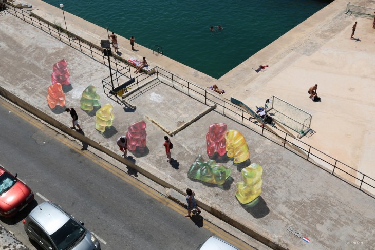 acera de una calle en malta con los dibujos de unos panditas y personas caminando por la calle 