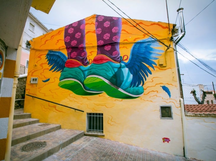 arte urbano en españa de los pies de una persona sobre una pared amarilla 