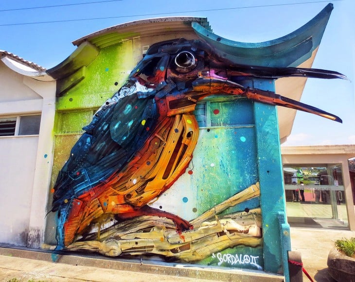 Arte urbano de un pájaro de colores pintado sobre una pared en Lisboa, Portugal