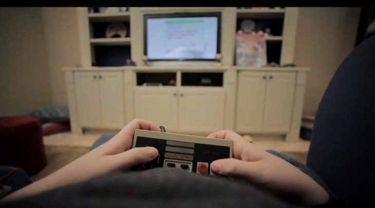 Manos de una persona jugando Nintendo en una sala 