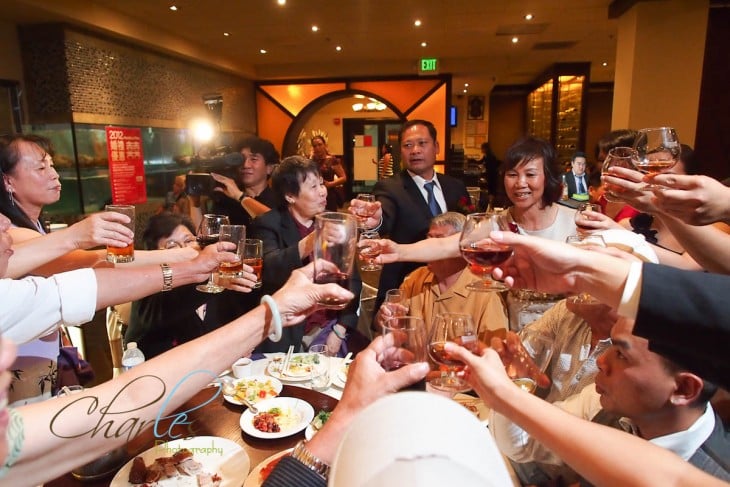 Personas brindando con copas alrededor de una mesa en un restaurante 