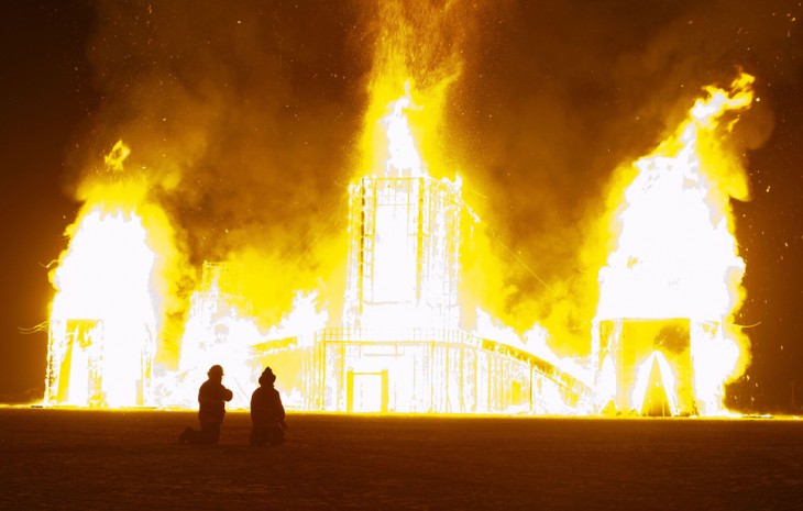Personas viendo como se quema algo durante el Festival Burning Man 