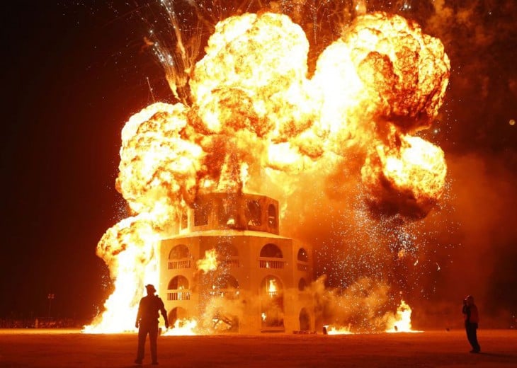 Personas frente a un edificio incendiado en el festival Burning Man 