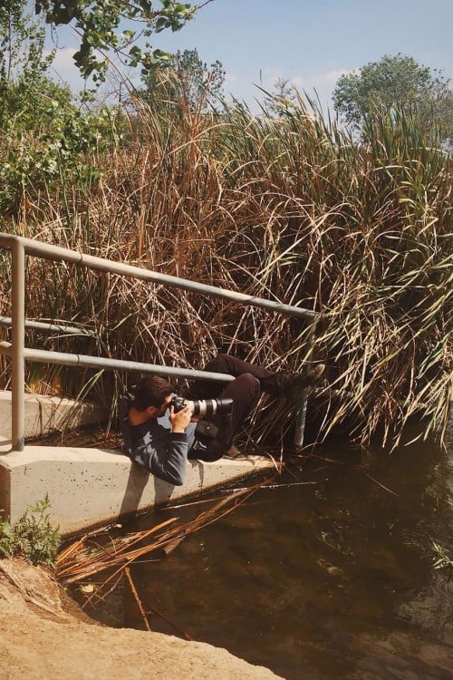 Chico tomando una fotografía sobre un pequeño puente 