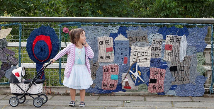 Niña sosteniendo una pequeña carreola por una calle de escocia 