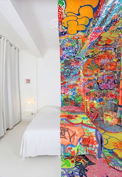 Fotografía de una habitación en Francia pintada la mitad blanca y la otra mitad con grafitis 